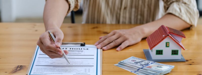 Following a deal with a broker, A Man signs a contract to rent a house